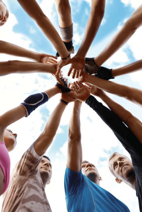 Samen sporten motiveert, een groep mensen leggen de hand bij elkaar in teamverband