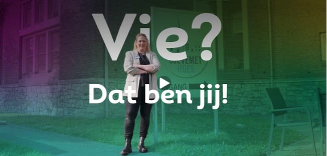Stillbeeld van de video 'Het verhaal van Desiree'. Desiree Verbocht van Impuls staat met gekruiste armen voor de ingang van 't Sjevemethoes. Het scherm heeft een kleurrijk filter. De grote witte tekst 'Vie? Dat ben jij!' en een afspeelknop zijn duidelijk zichtbaar in het midden.