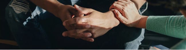 Een hand op iemands arm als symbool voor steun en mentale gezondheid tijdens de Week van de Mentale Gezondheid van Vie.