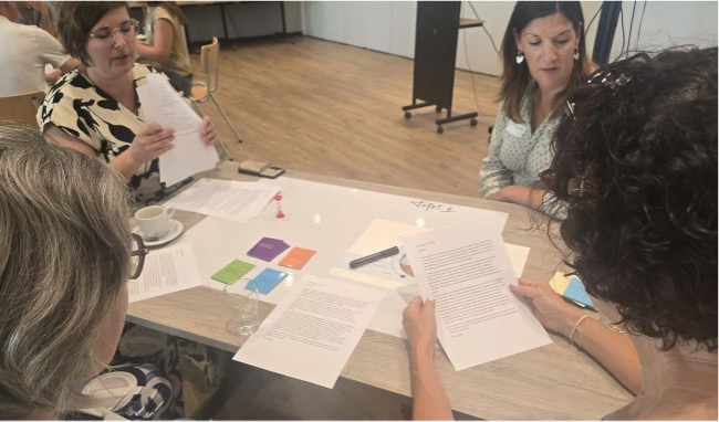 Personen in overleg aan een tafel met papieren